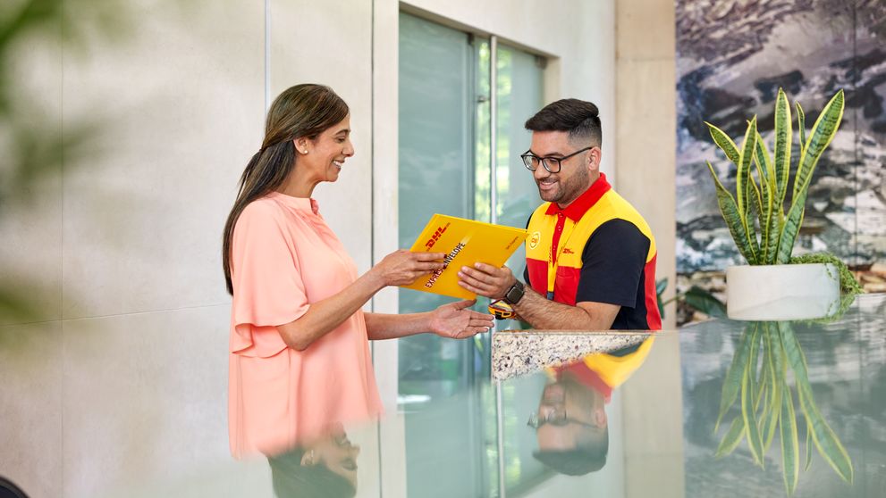 male dhl express employee handing over a delivery to a woman