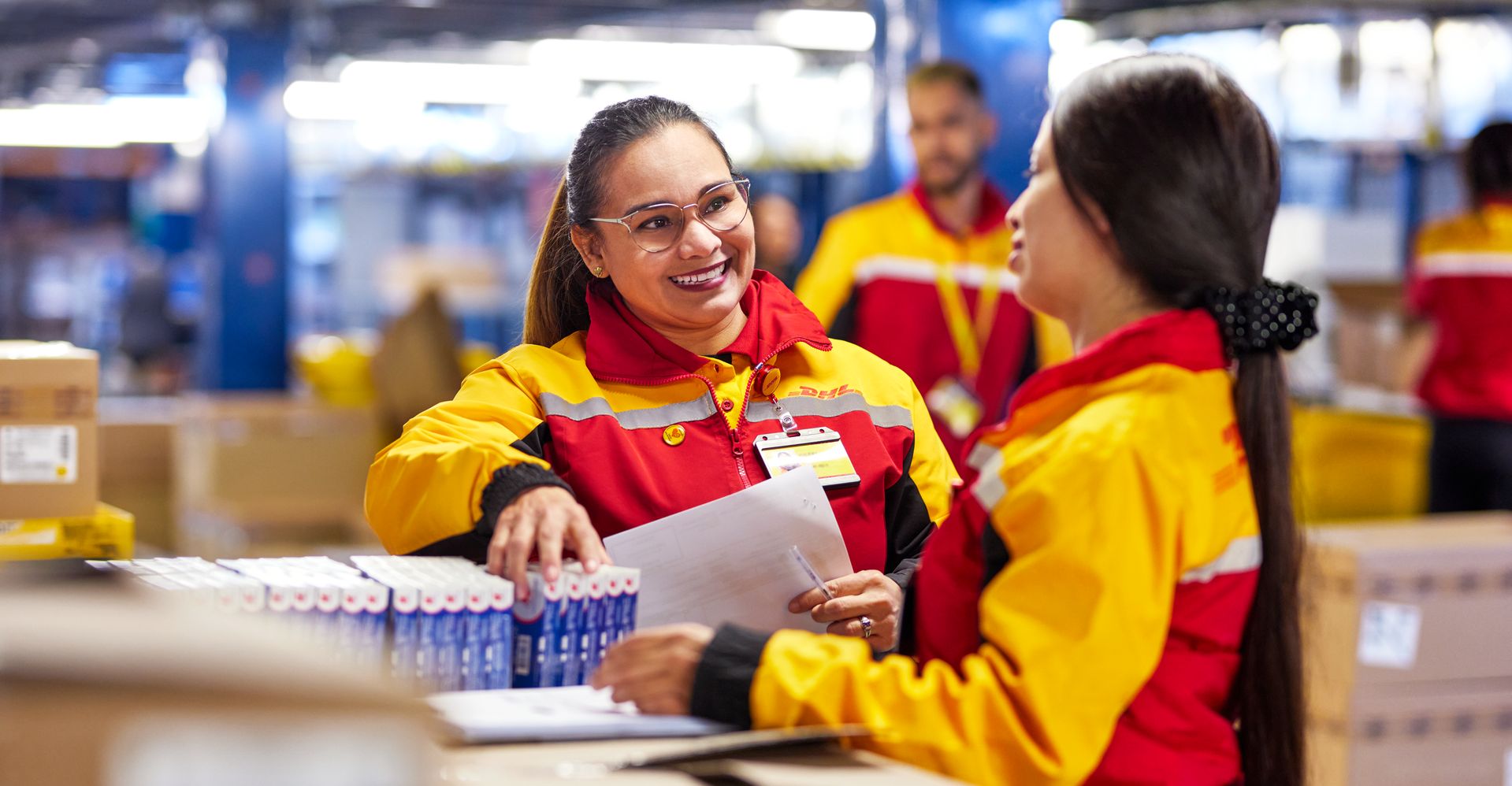 DHL Express employees inspecting the goods in preparation for international shipping