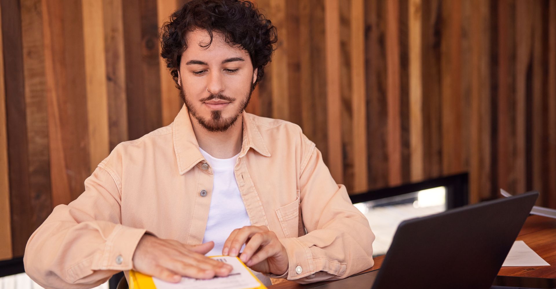 A male livestream salesperson is sticking a label on a DHL express parcel at home.