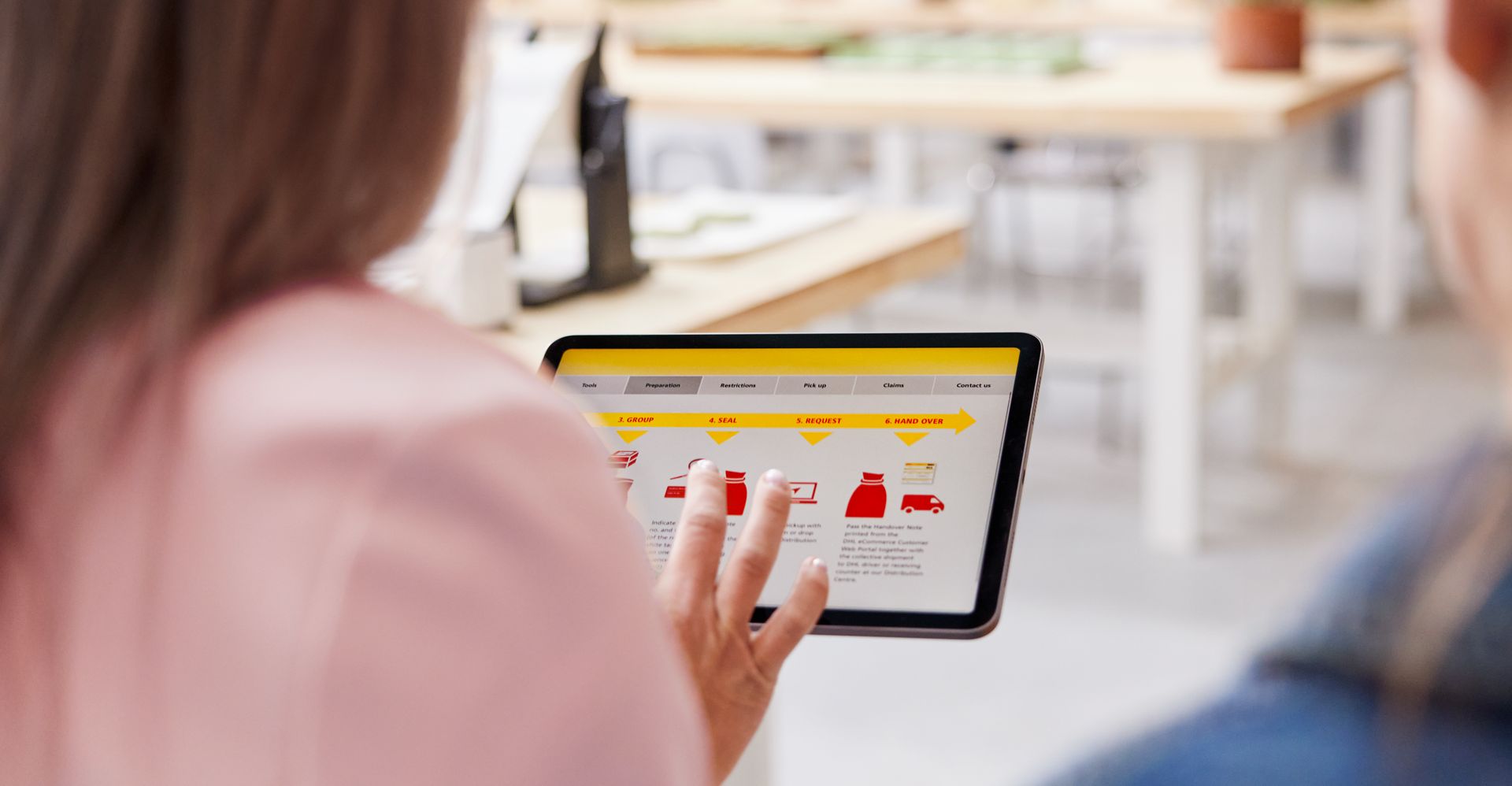 a person checking dhl shipping solutions on a tablet during a consultation