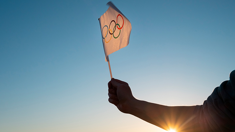 hand waving olympic flag