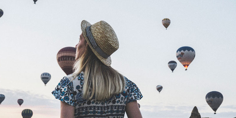 woman looking up at hot air balloons
