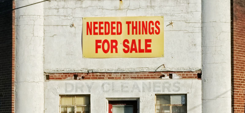Dry cleaners with things for sale sign