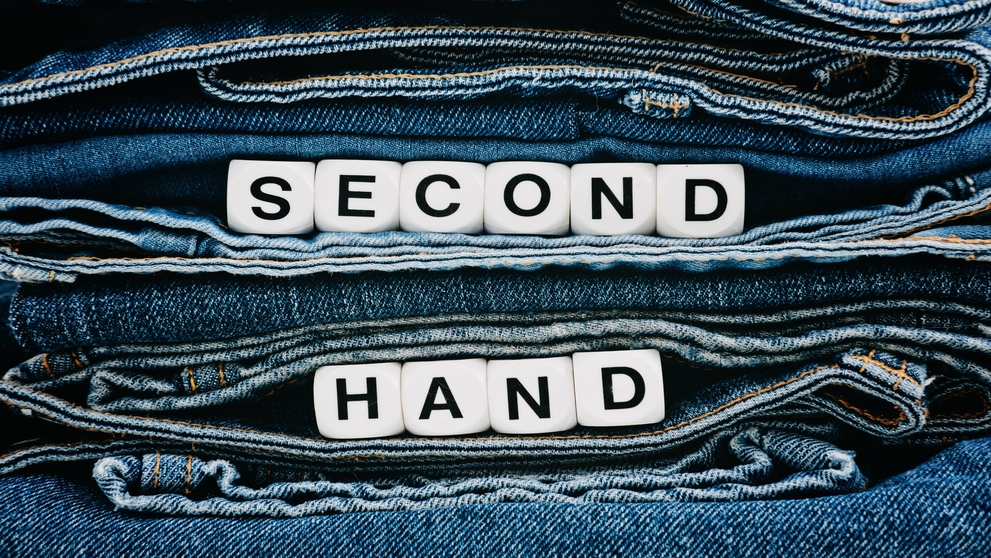 Second hand, Vintage Shopping, slow fashion, Sustainable fashion concept. Stack of blue old denim jeans with the words second hand