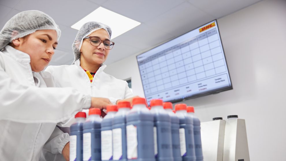 Two women wearing personal protective gear in a lab